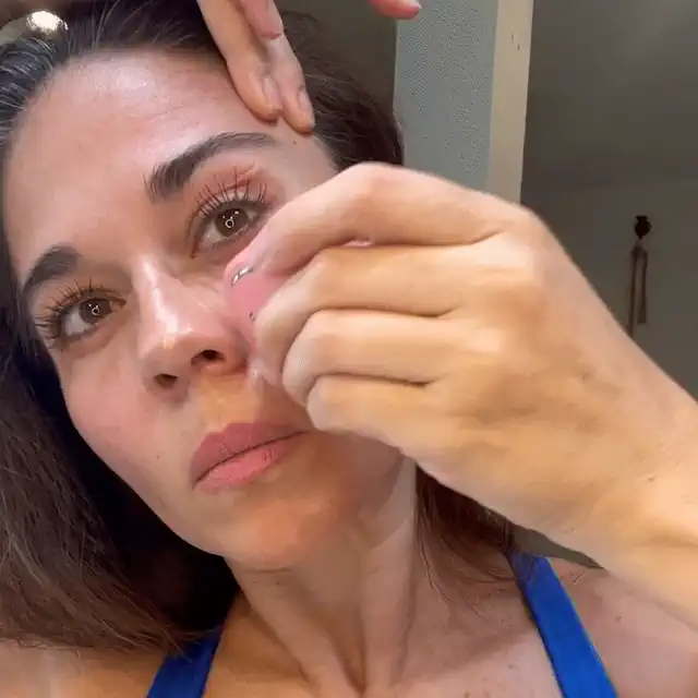 Mujer usando el dispositivo de microcorriente en casa